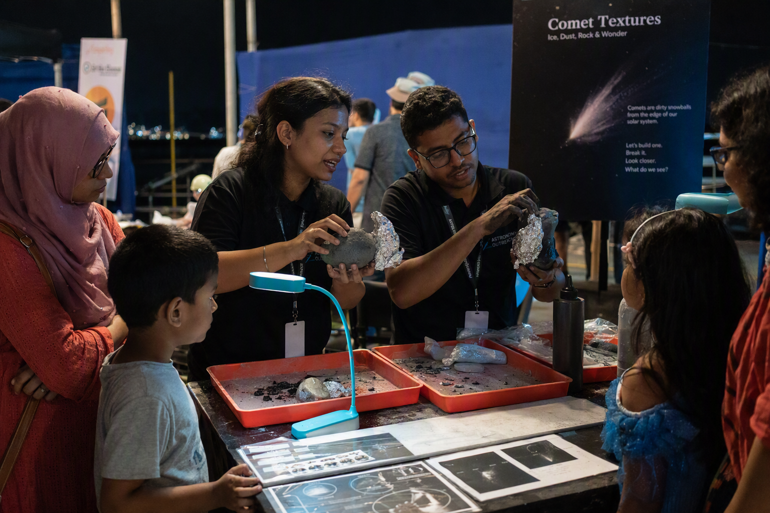 Children and adults using ribbons, fans, and glowing models to investigate comet tails together