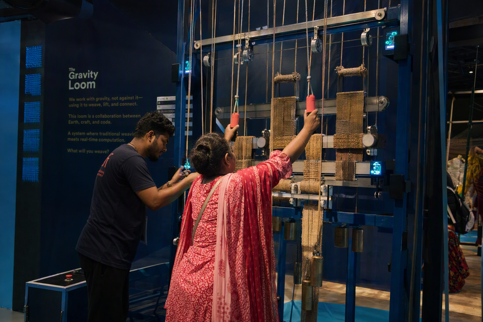 Visitors pulling illuminated cords across the Gravity Loom to bend a projected grid